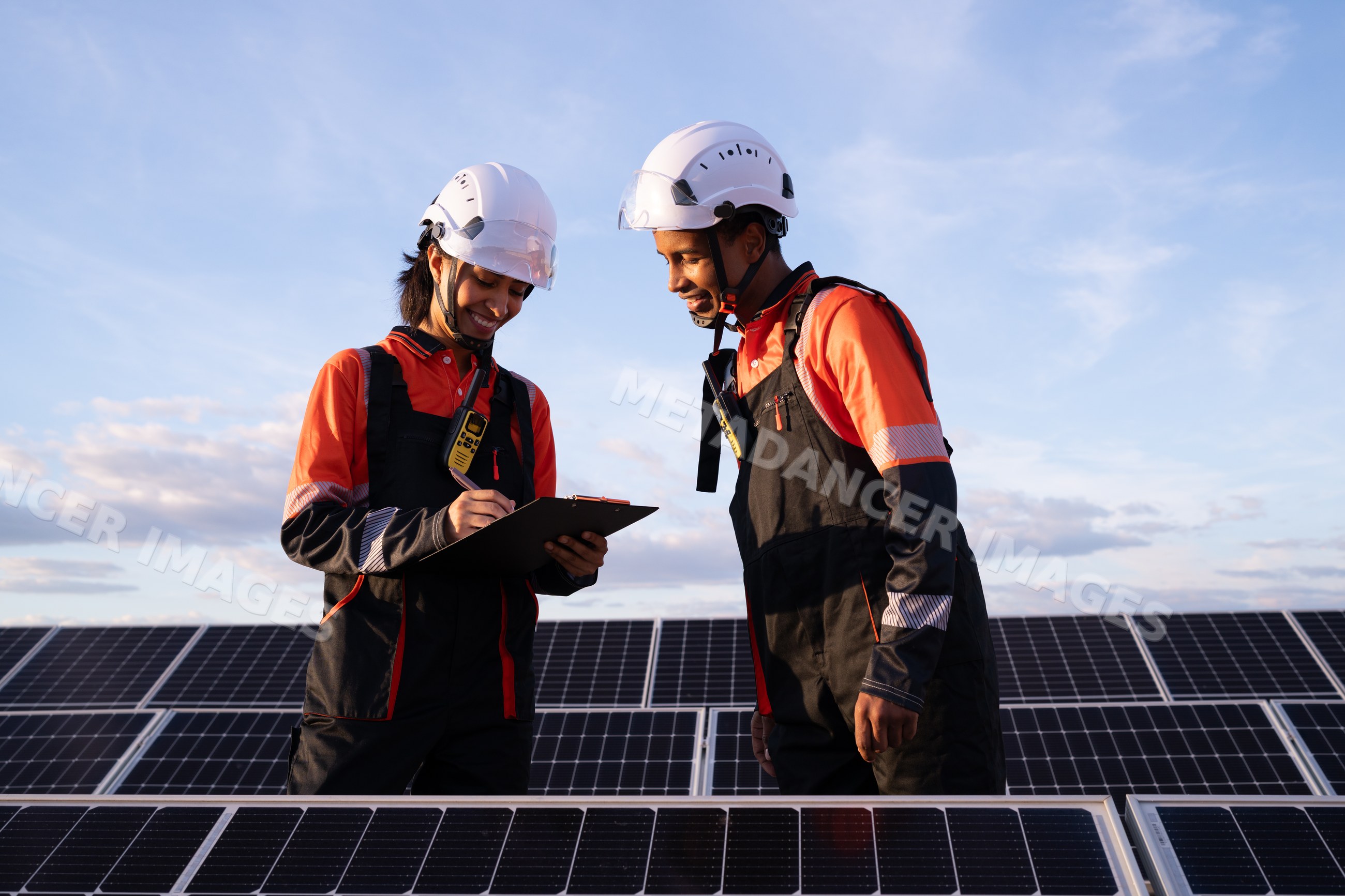 Hispanic workers inspecting solar panels