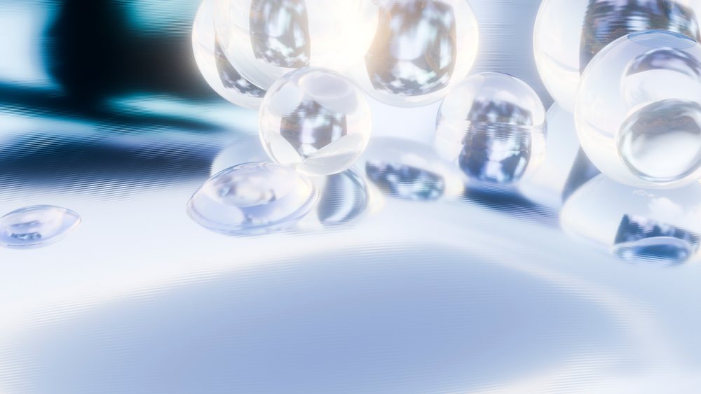 Transparent glass spheres reflecting light on smooth surface