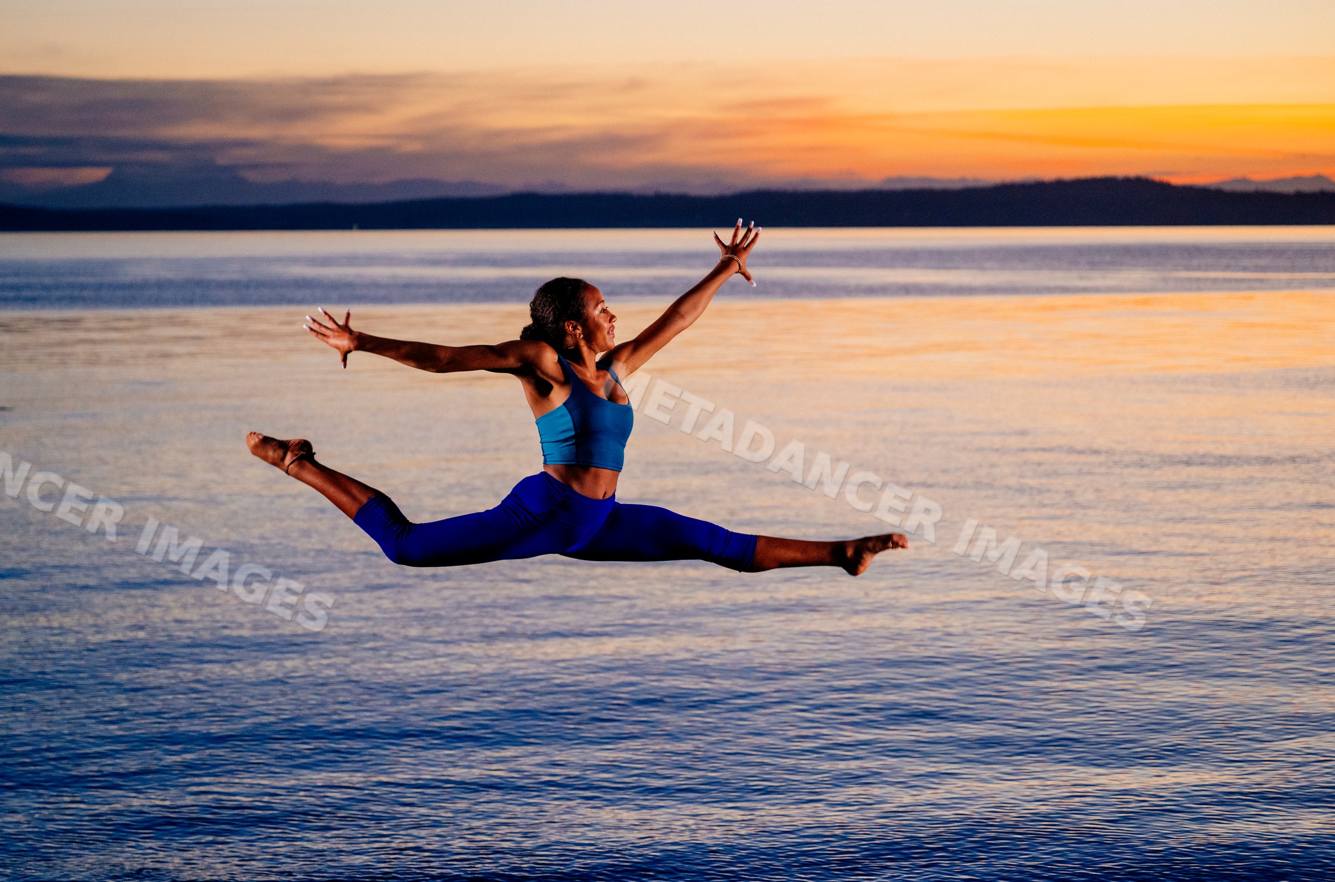 Hispanic woman performing split leap yoga pose outdoors