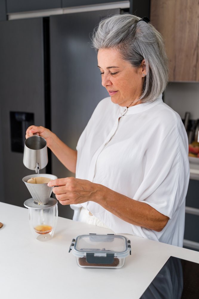 White Woman making pour over coffee in modern home kitchen