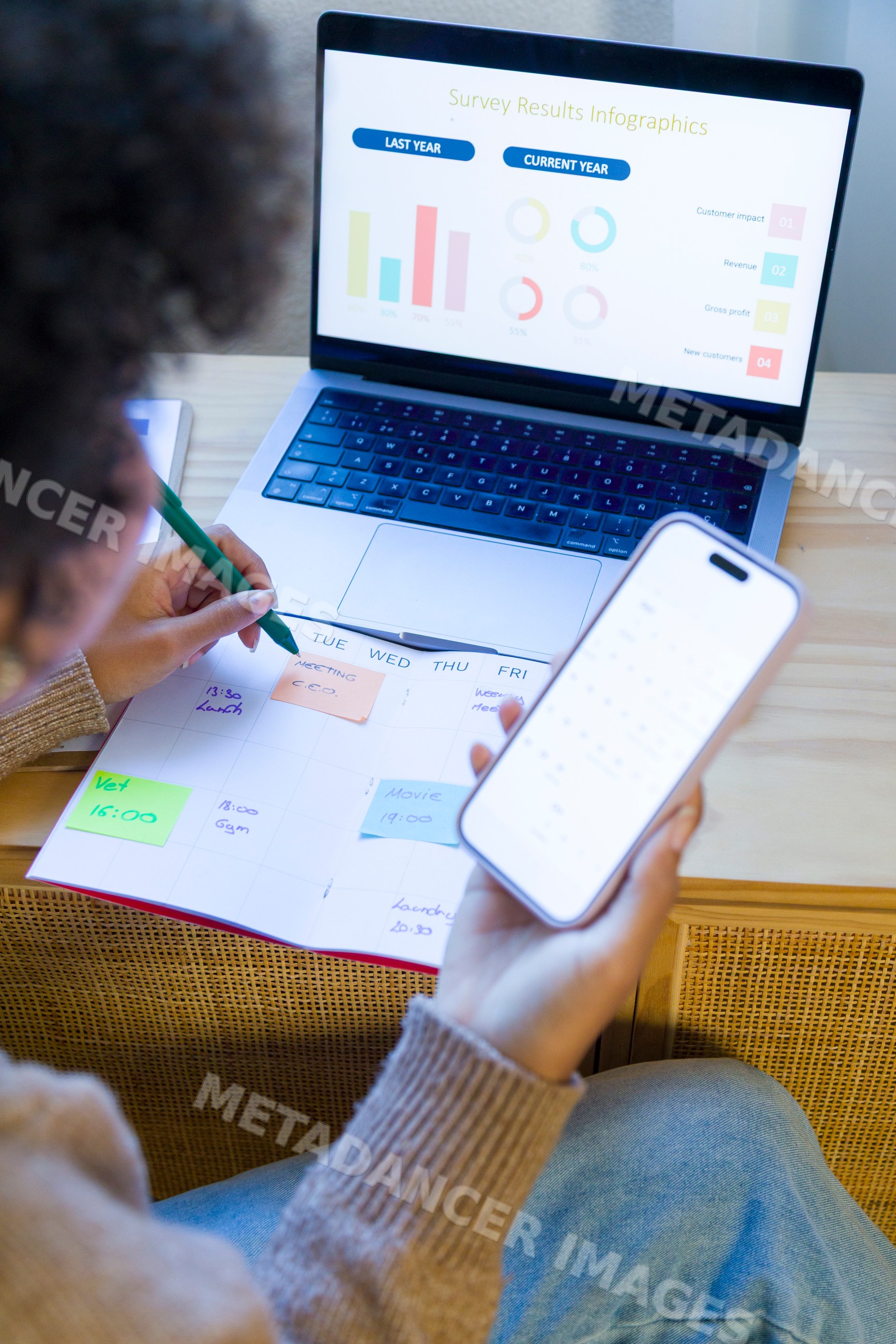 African American woman planning schedule with calendar and smartphone
