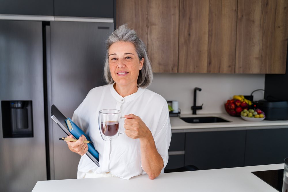 Mature white woman holding coffee and notebook