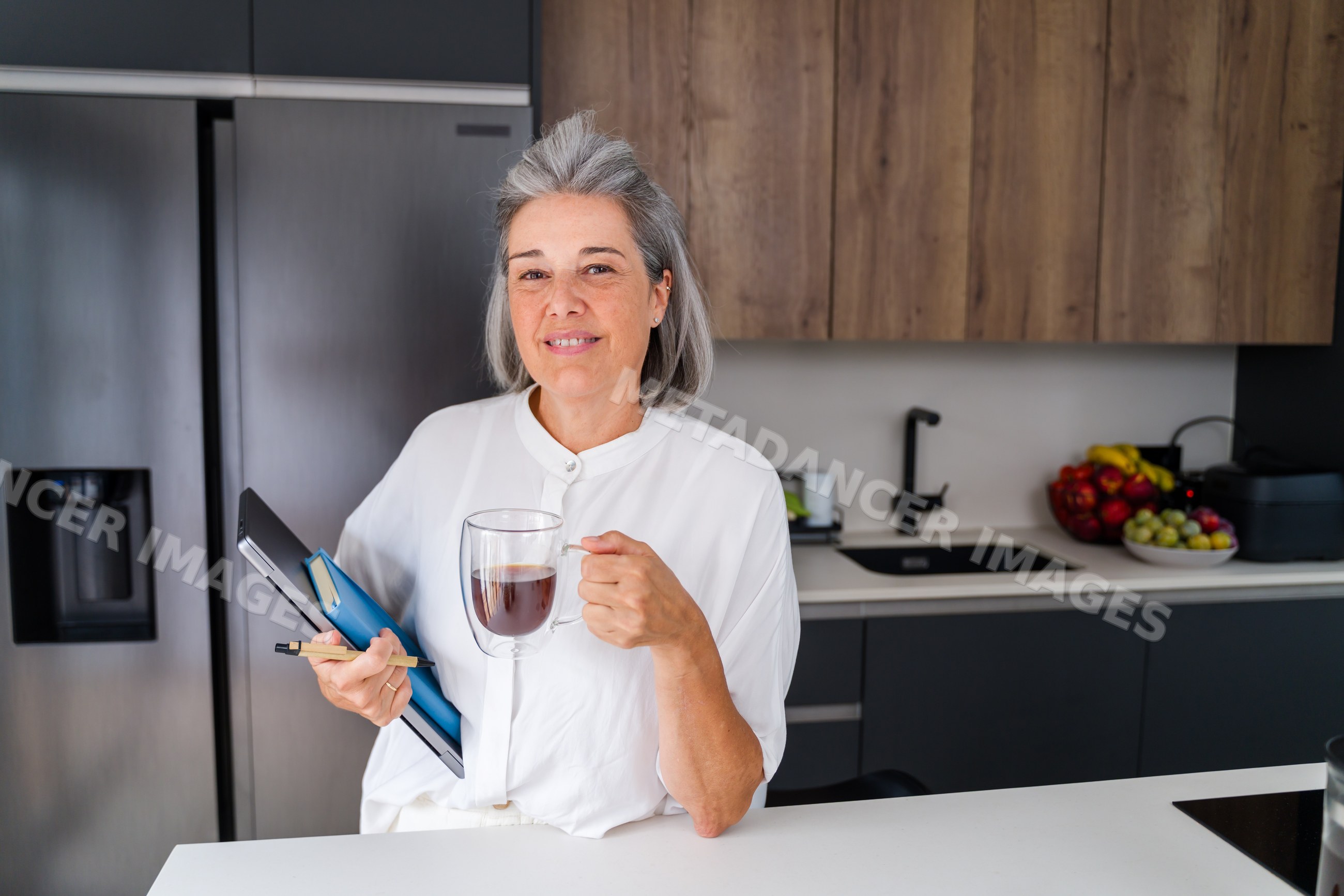 Mature white woman holding coffee and notebook