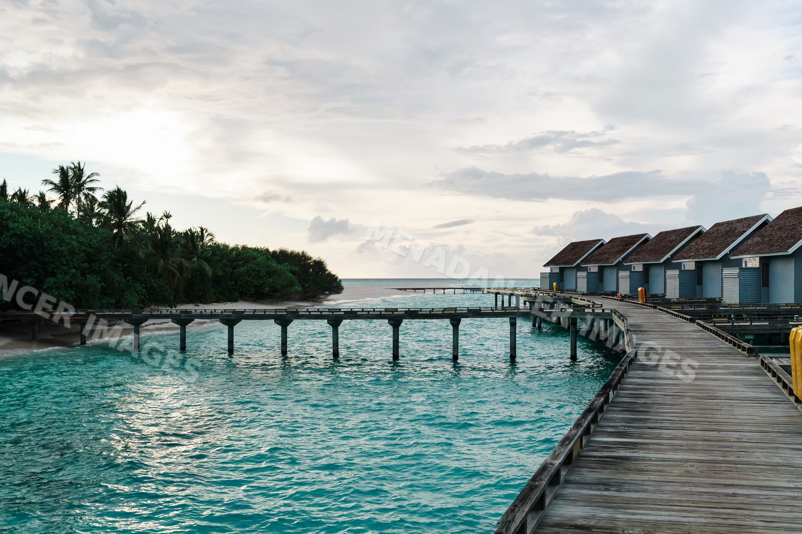 Wooden walkway to overwater bungalows at a tropical resort in a beach
