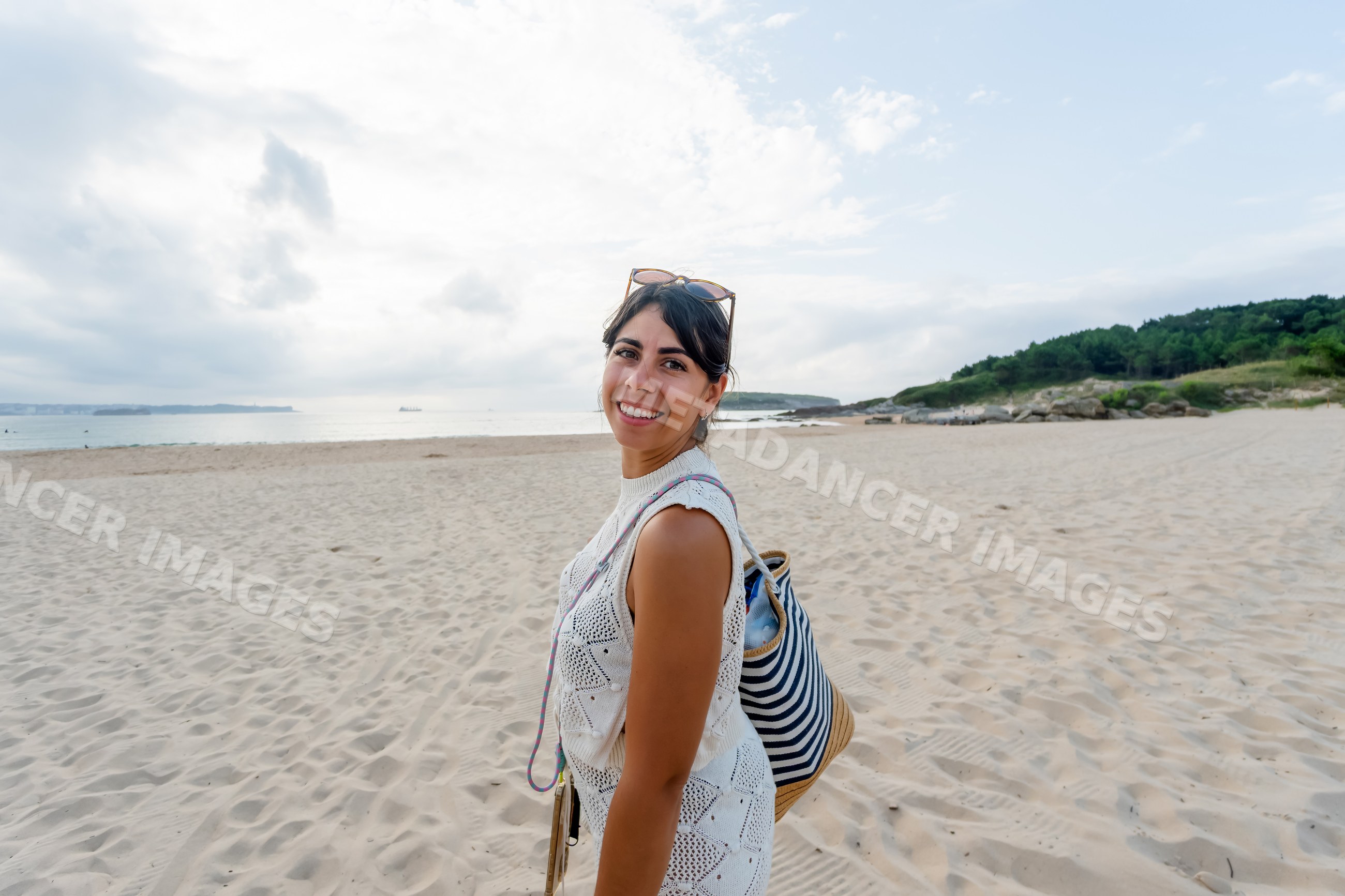 Smiling white woman enjoying time on sandy beach by the sea in a beach