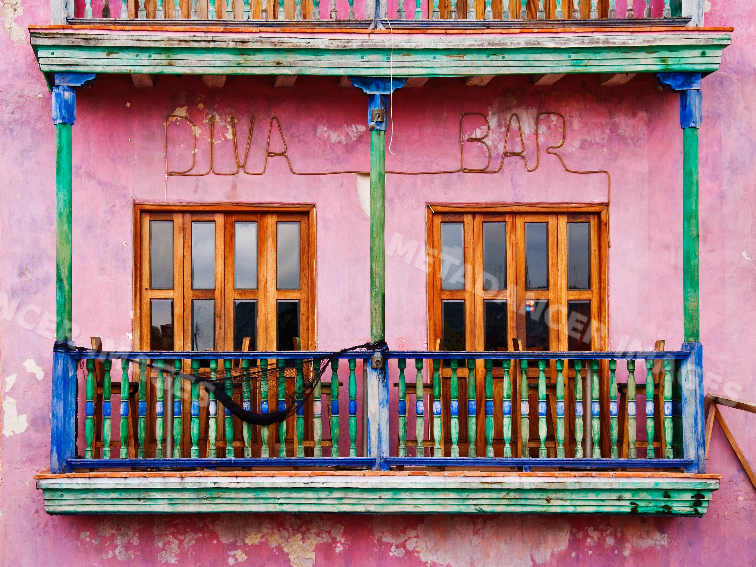 Colorful building facade with wooden balcony and diva bar sign
