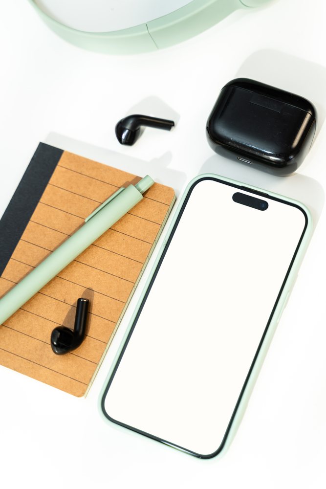 Smartphone with wireless earbuds, notebook