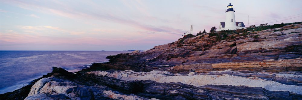 Pemaquid lighthouse on rocky coastline at sunset USA