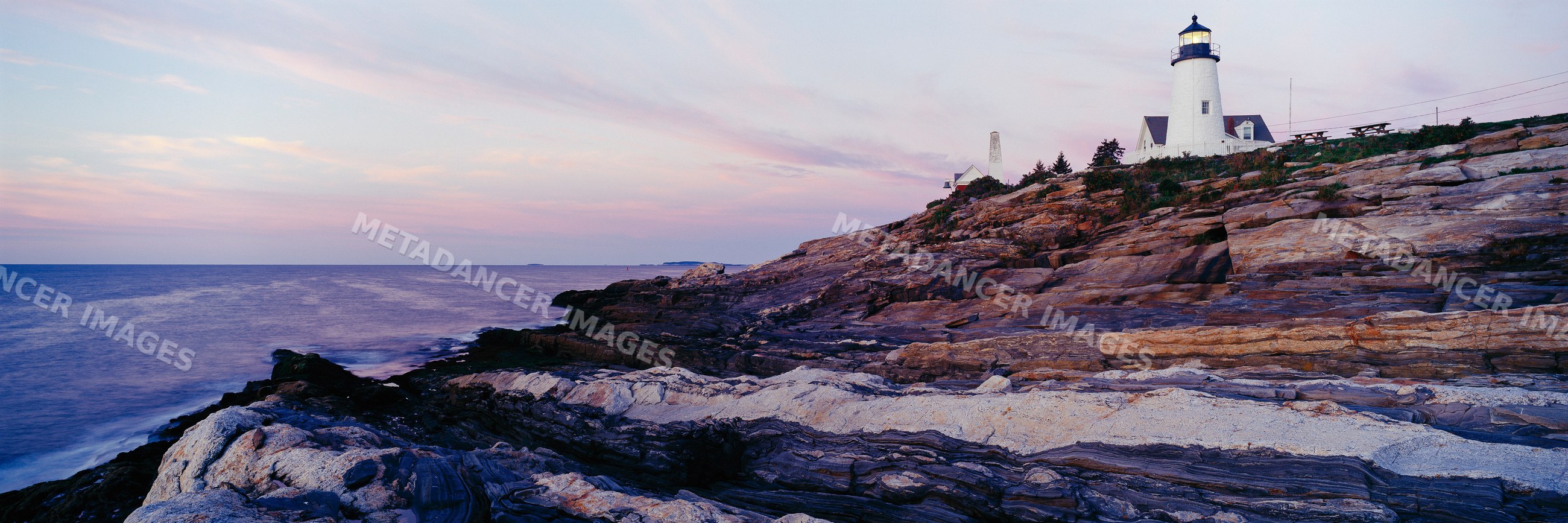 Pemaquid lighthouse on rocky coastline at sunset USA