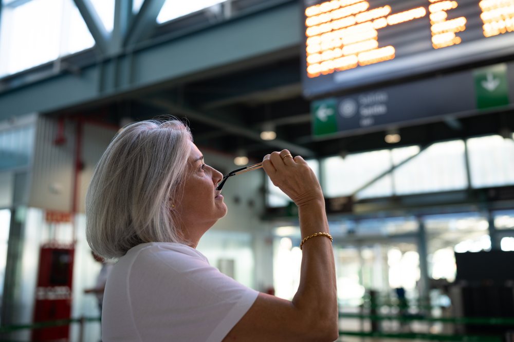 White woman examining departure board inside train station in Spain