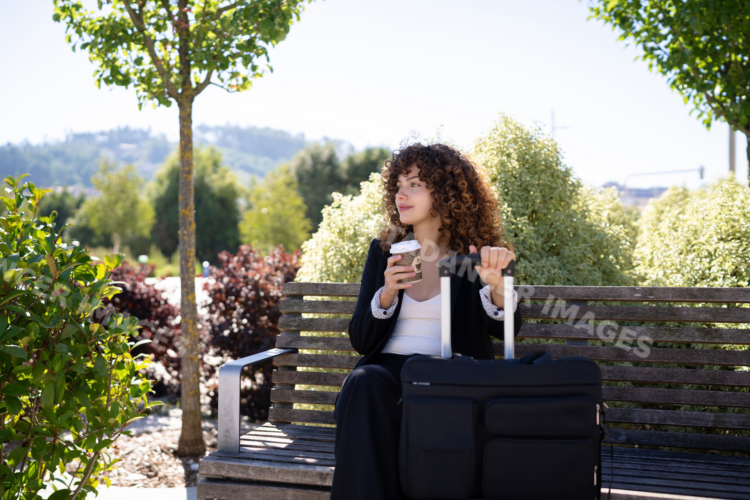 White woman with suitcase enjoys coffee