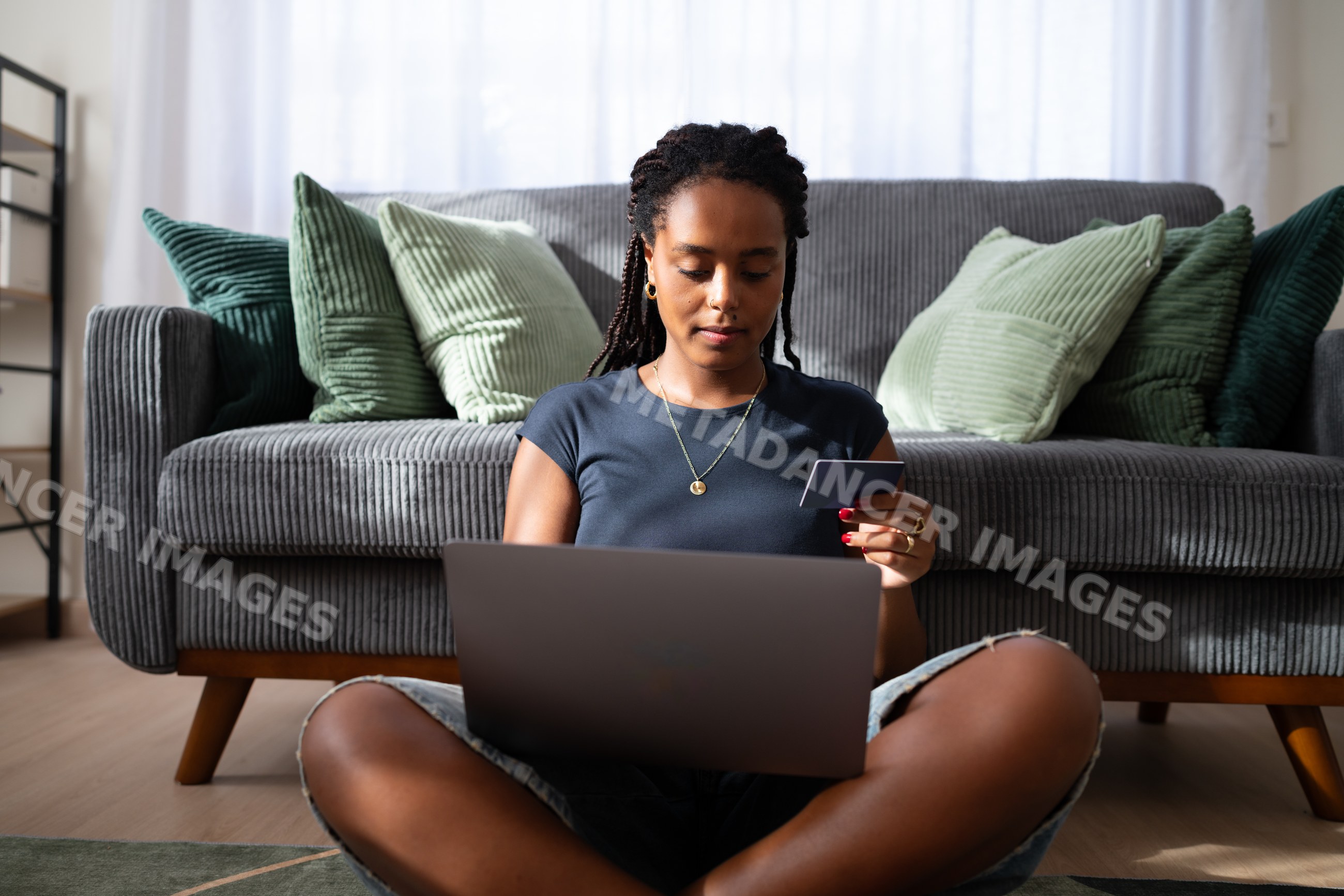 African American woman uses a laptop and payment card for online