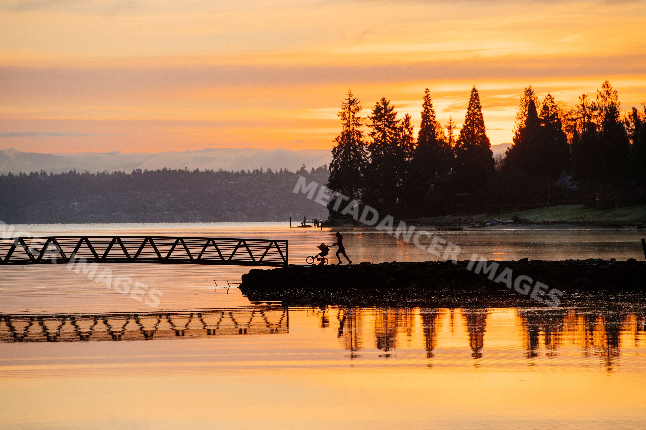 Sunset silhouette of a woman with a stroller