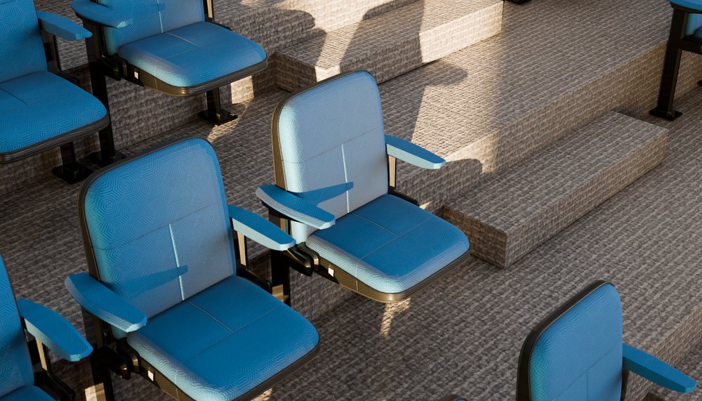 Blue cushioned theatre seats on tiered carpeted steps