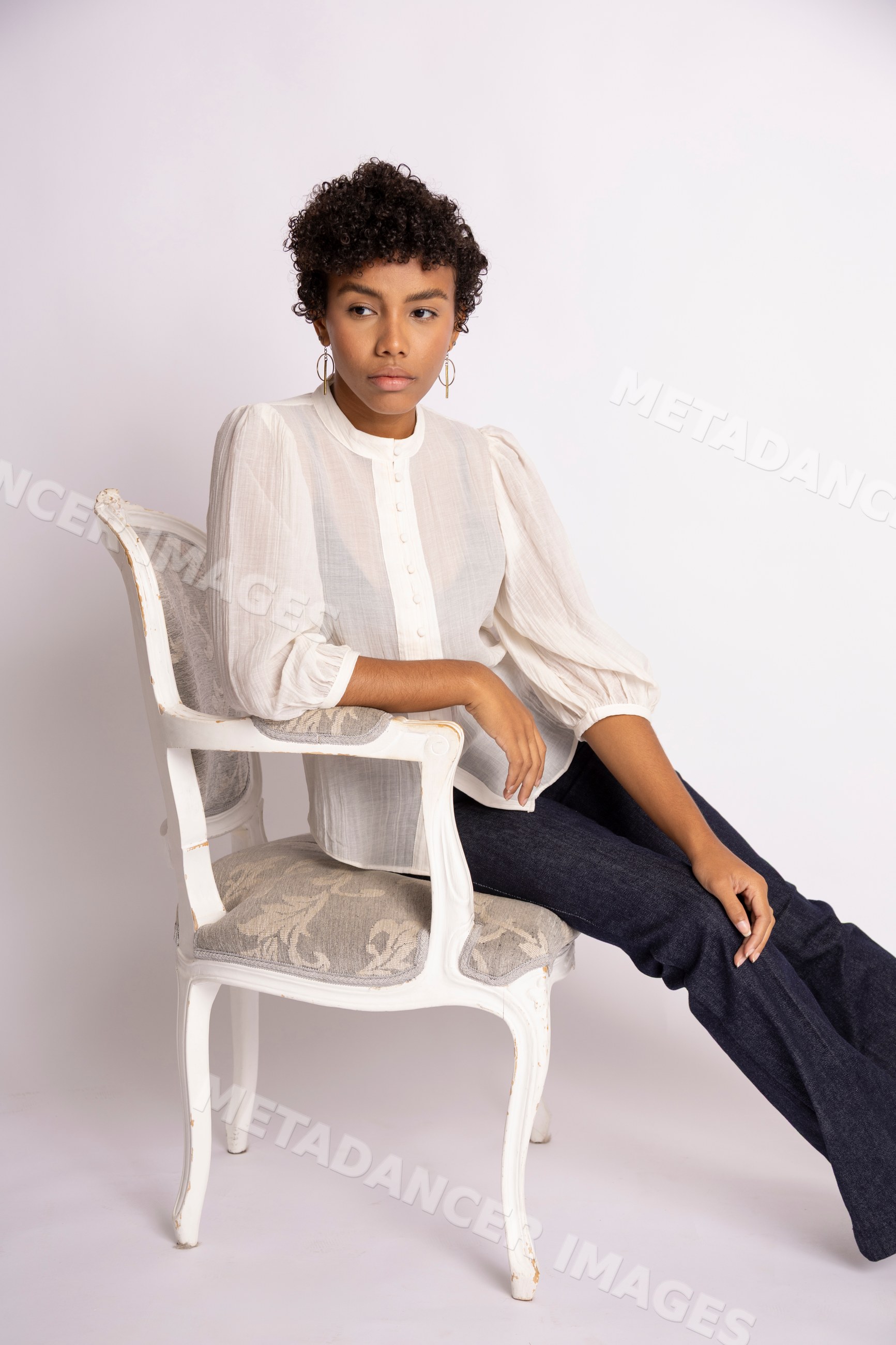 Hispanic woman sitting on vintage-style chair