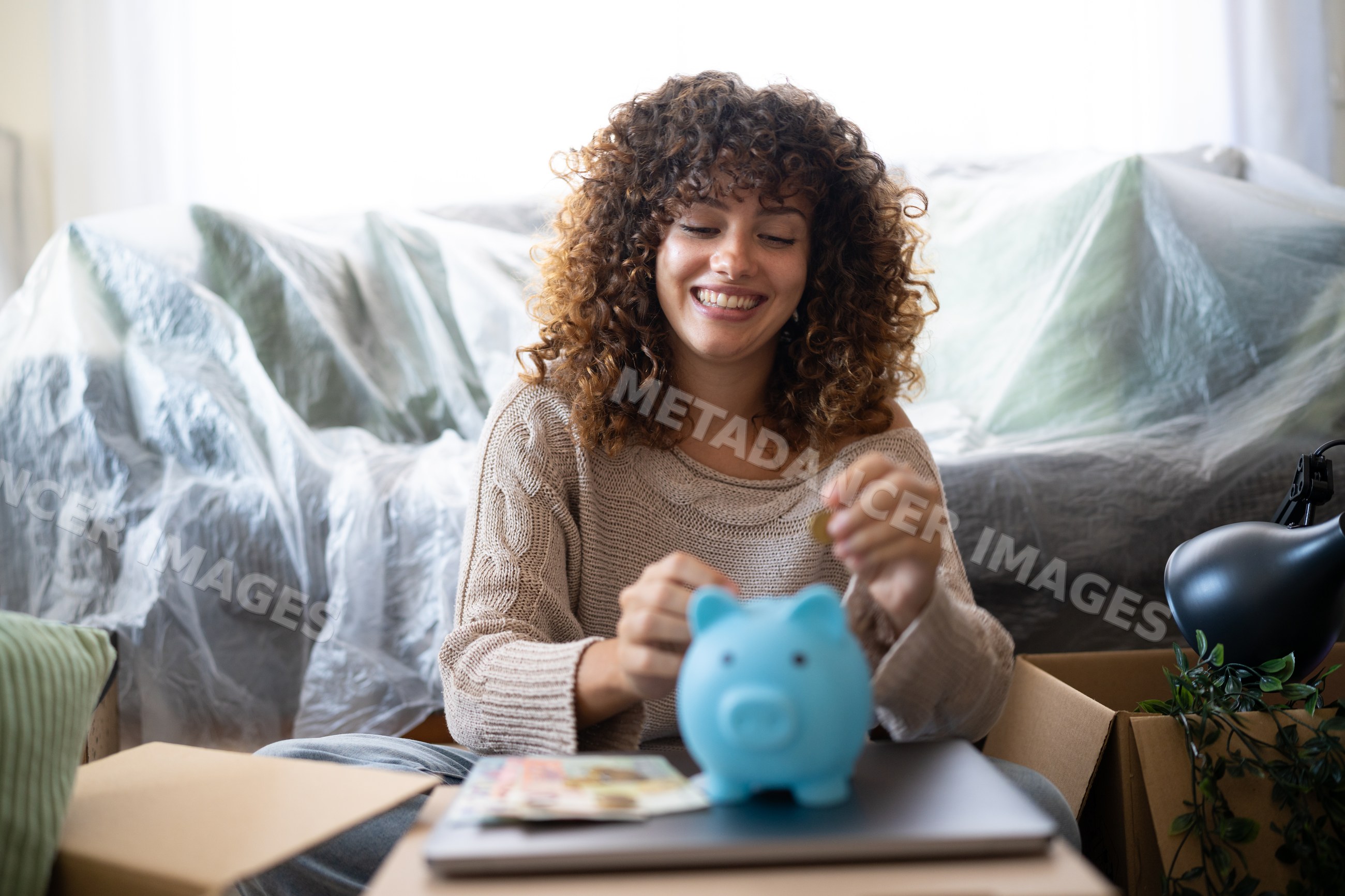 White woman inserting coin into piggy bank during move