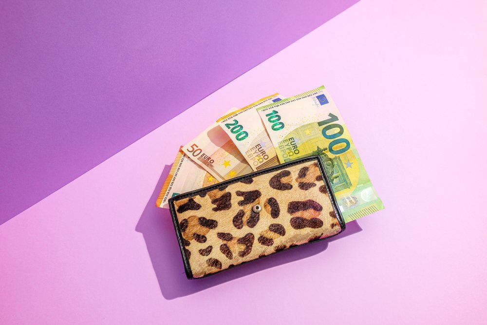 Wallet with euro banknotes on purple studio background