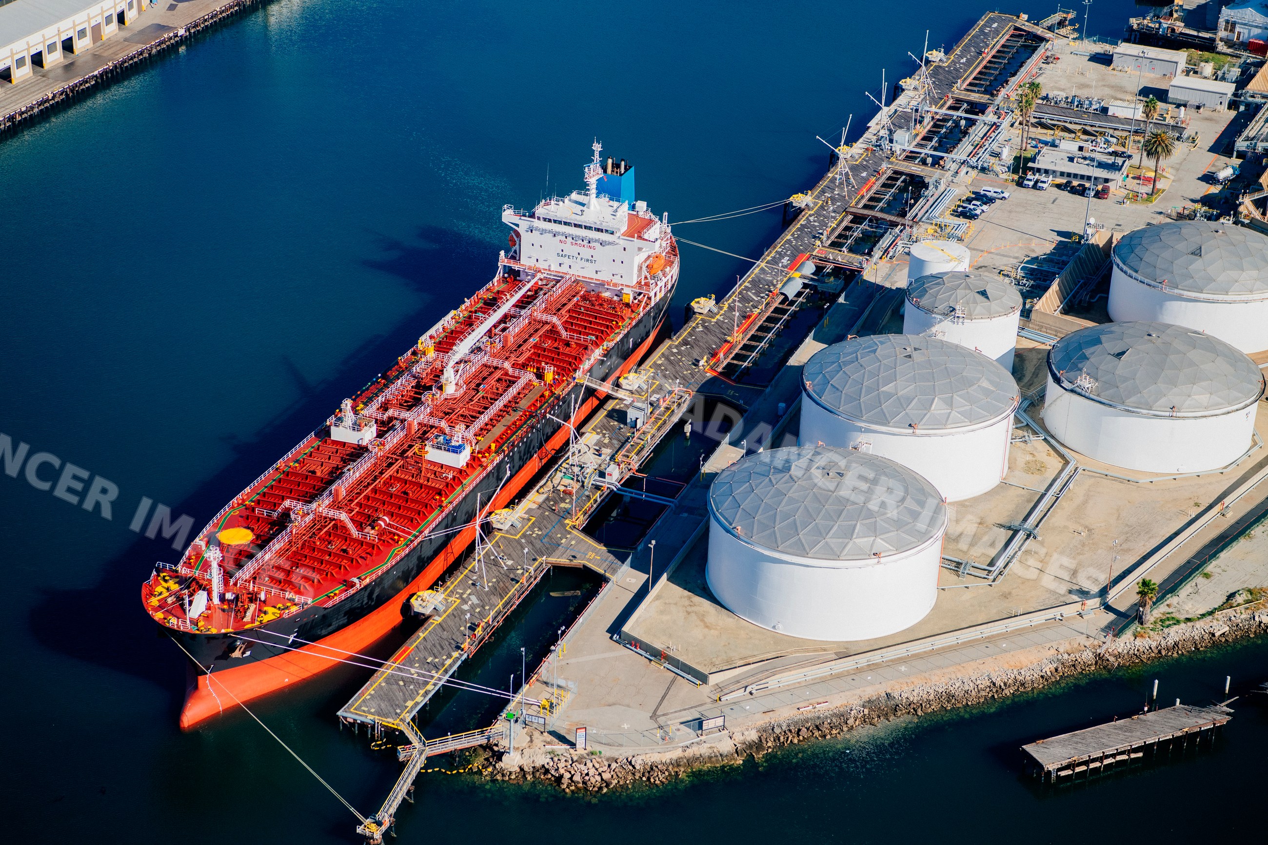 Oil tanker docked at storage tanks in a beach
