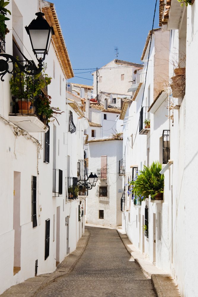 Narrow street with white houses and balconies, valencia, Spain