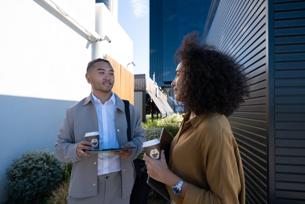 Two people chatting and having coffee outdoors