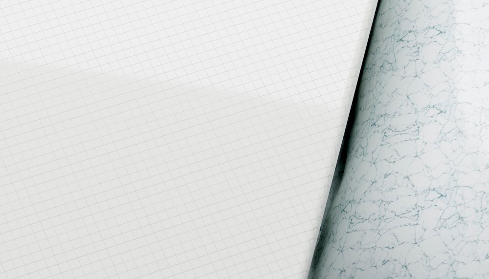 Close-up rendering of white grid paper curled beside a marbled sheet