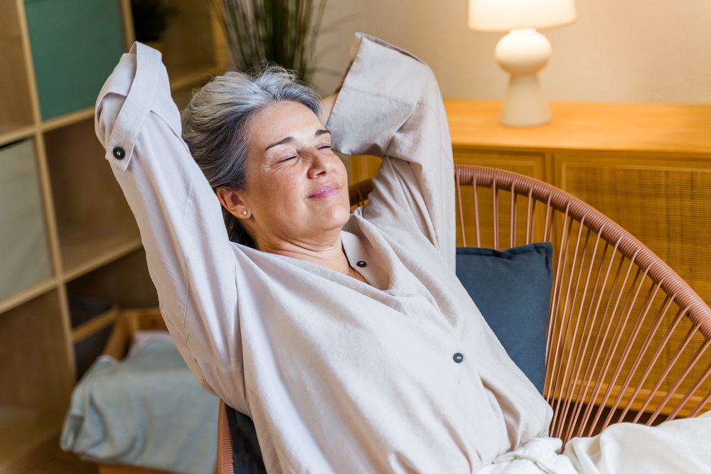 White woman relaxing in a chair indoors with peaceful expression