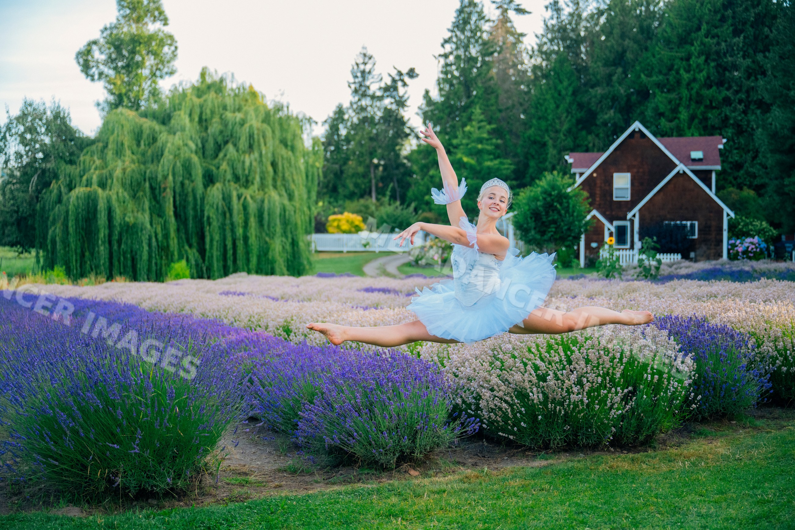 A ballerina performs a split leap outdoors