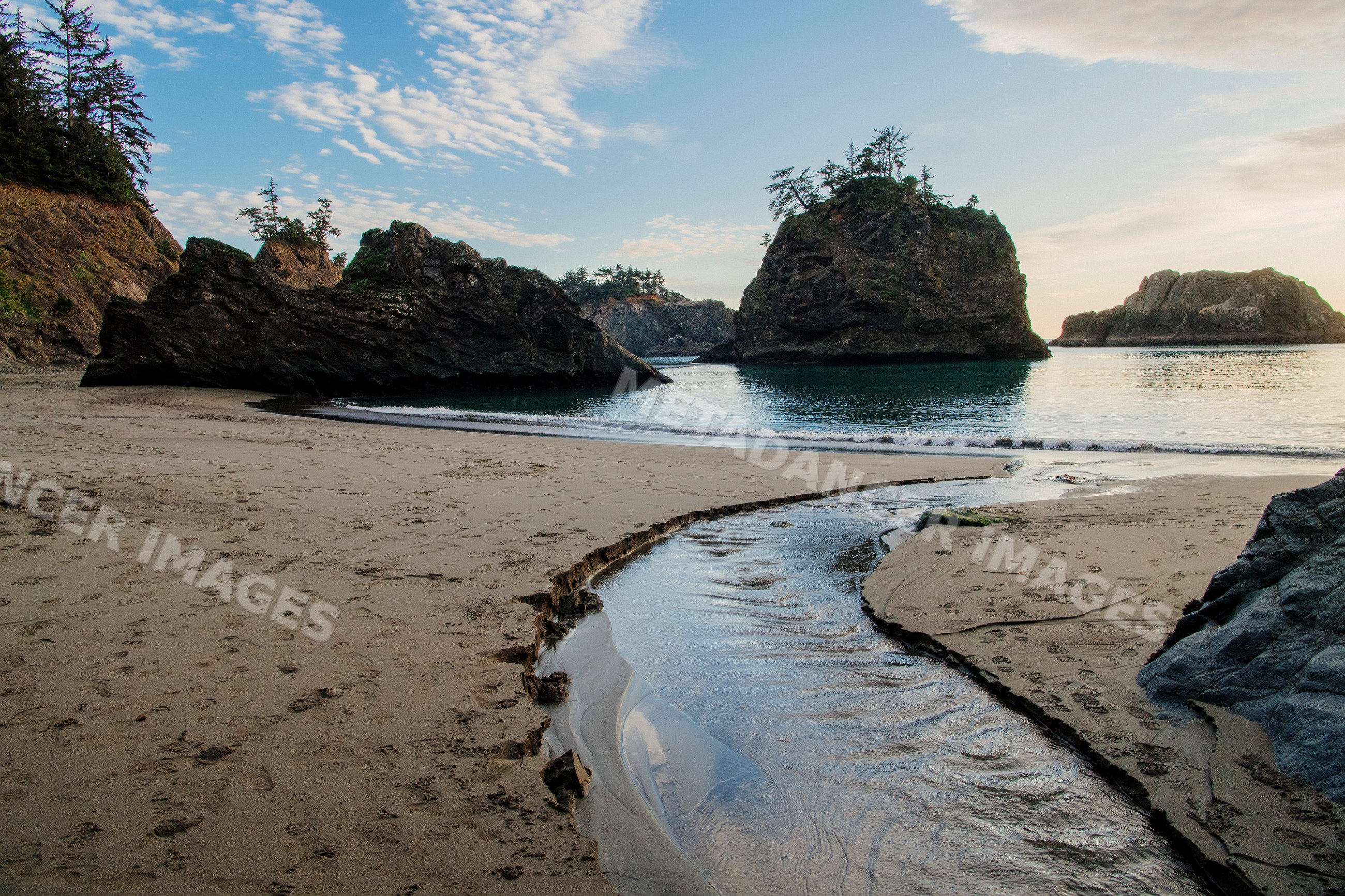 Beach with rock formations and water stream, Oregon