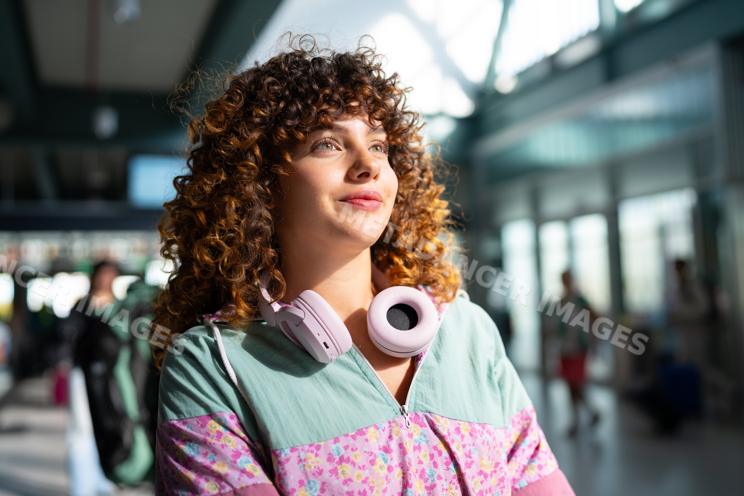 White woman wearing headphones inside airport terminal in Spain