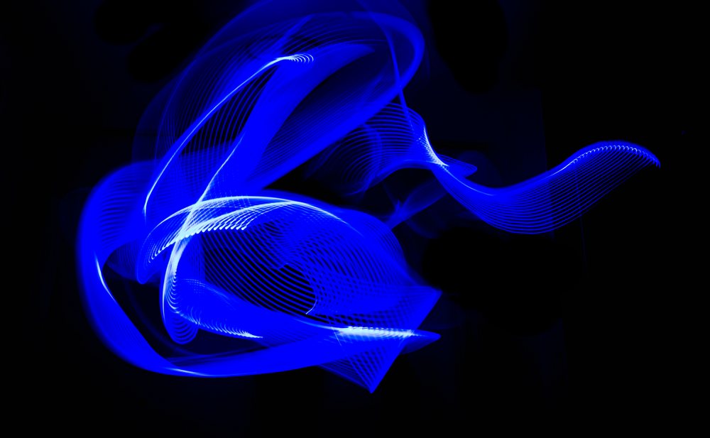 Blue light trails creating abstract swirling shapes in light painting