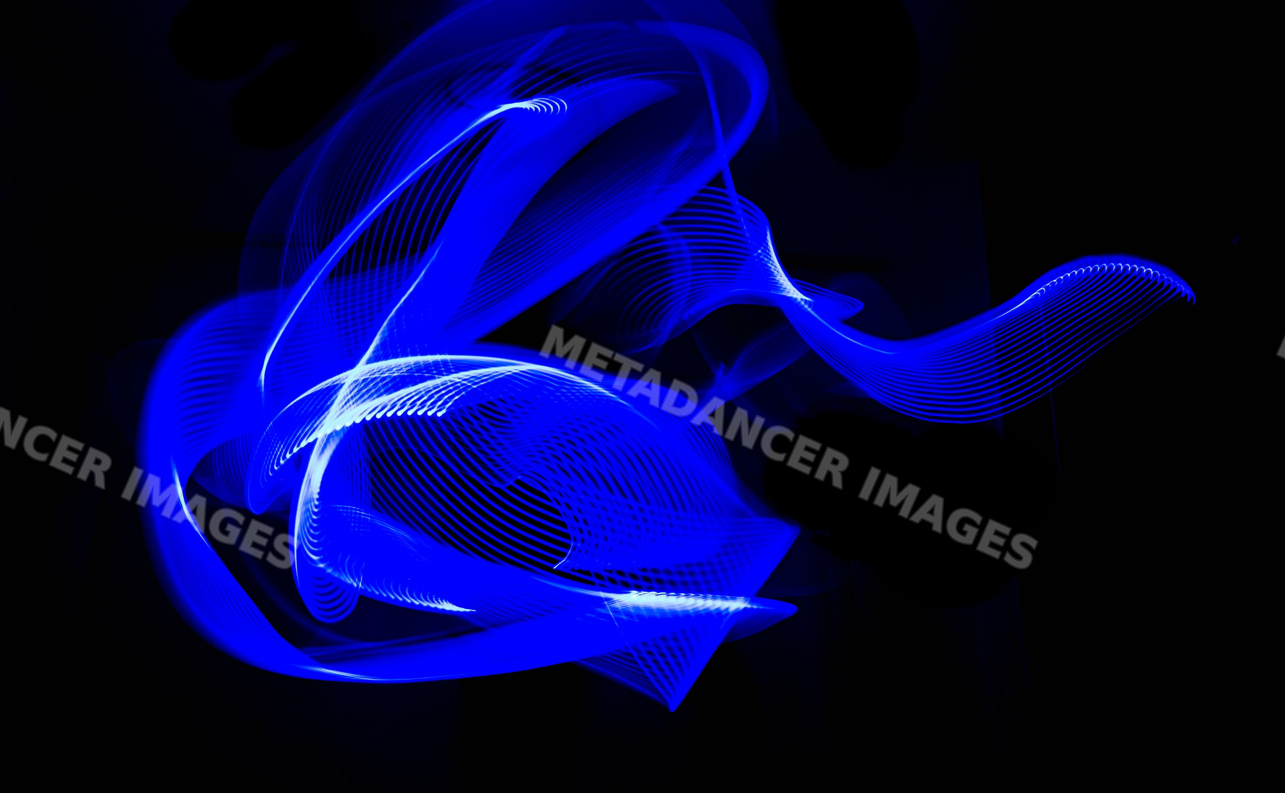 Blue light trails creating abstract swirling shapes in light painting