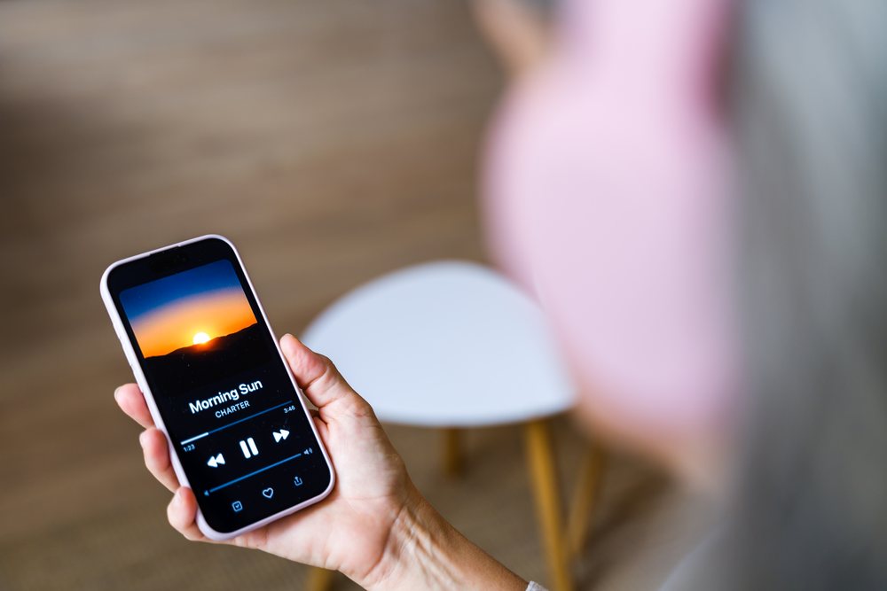 Smartphone playing morning sun music indoors with hand holding device