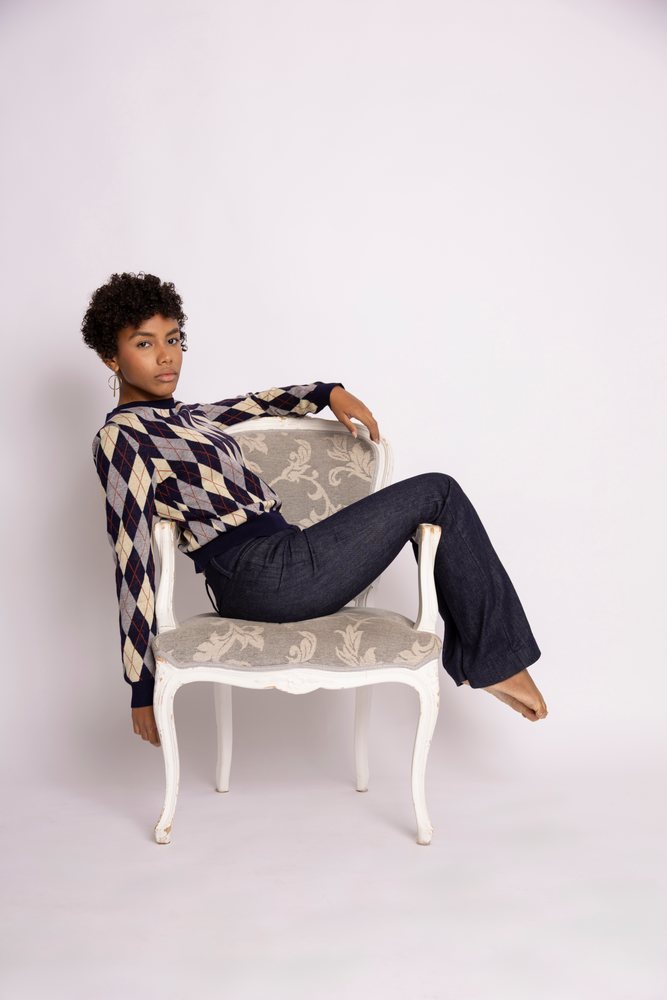 Young Hispanic woman posing on armchair in studio fashion photo