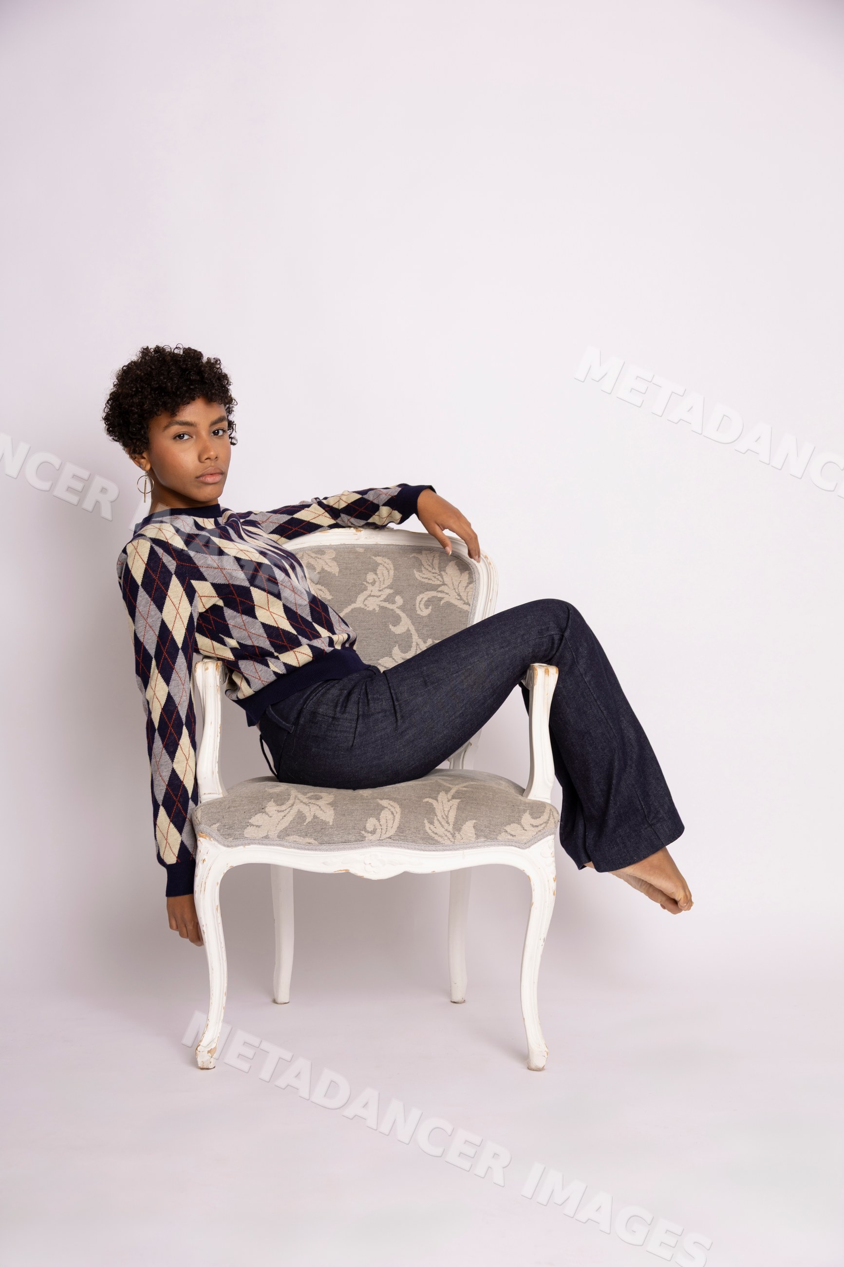 Young Hispanic woman posing on armchair in studio fashion photo