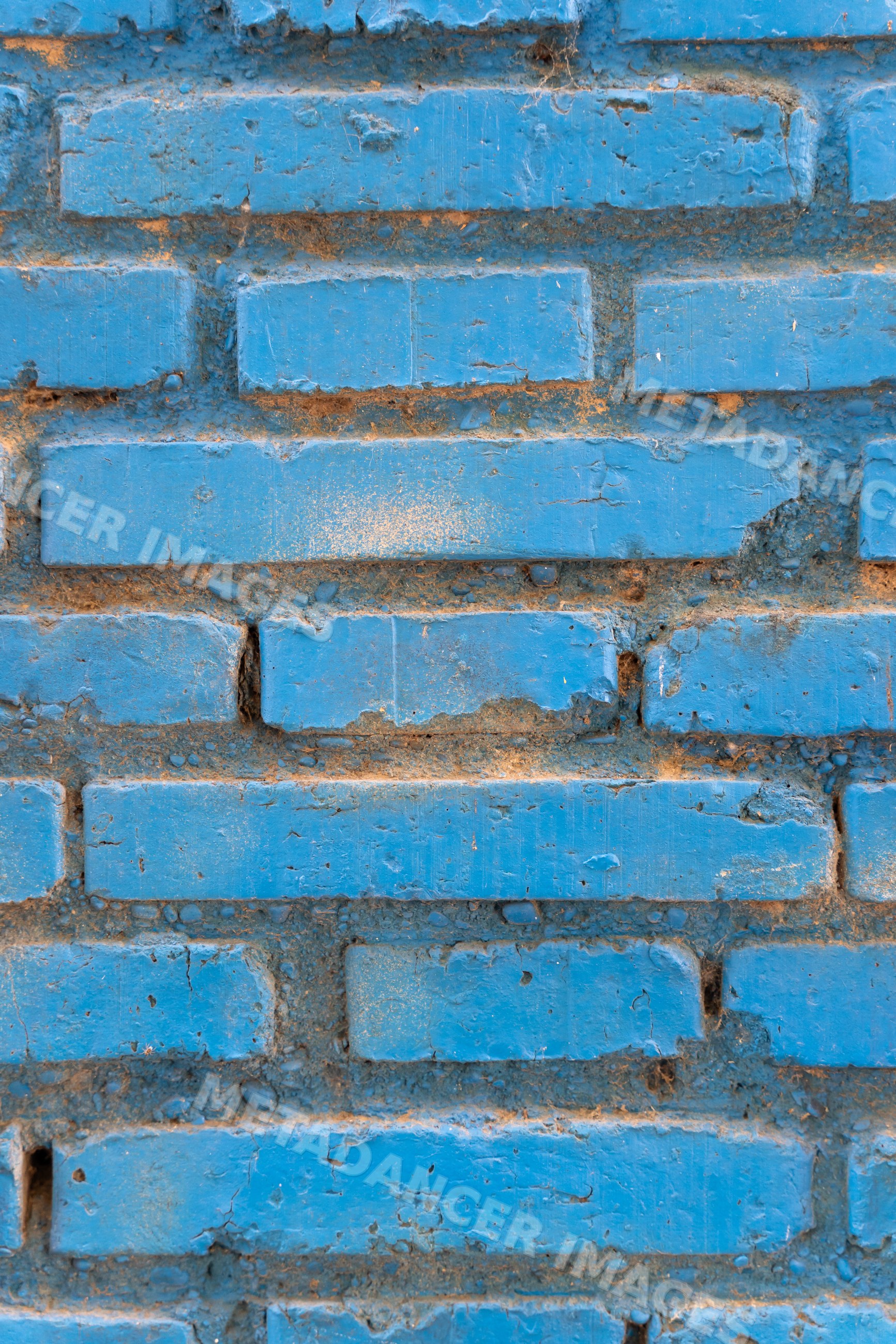 Blue painted brick wall with weathered texture
