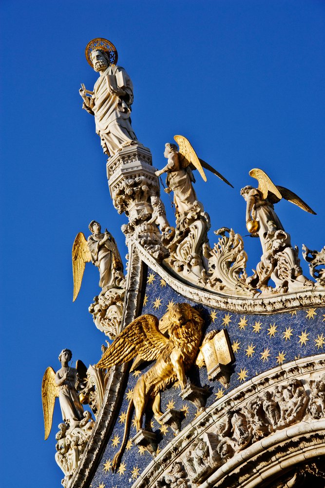 Statue of st. mark with angel sculptures and golden lion, italy