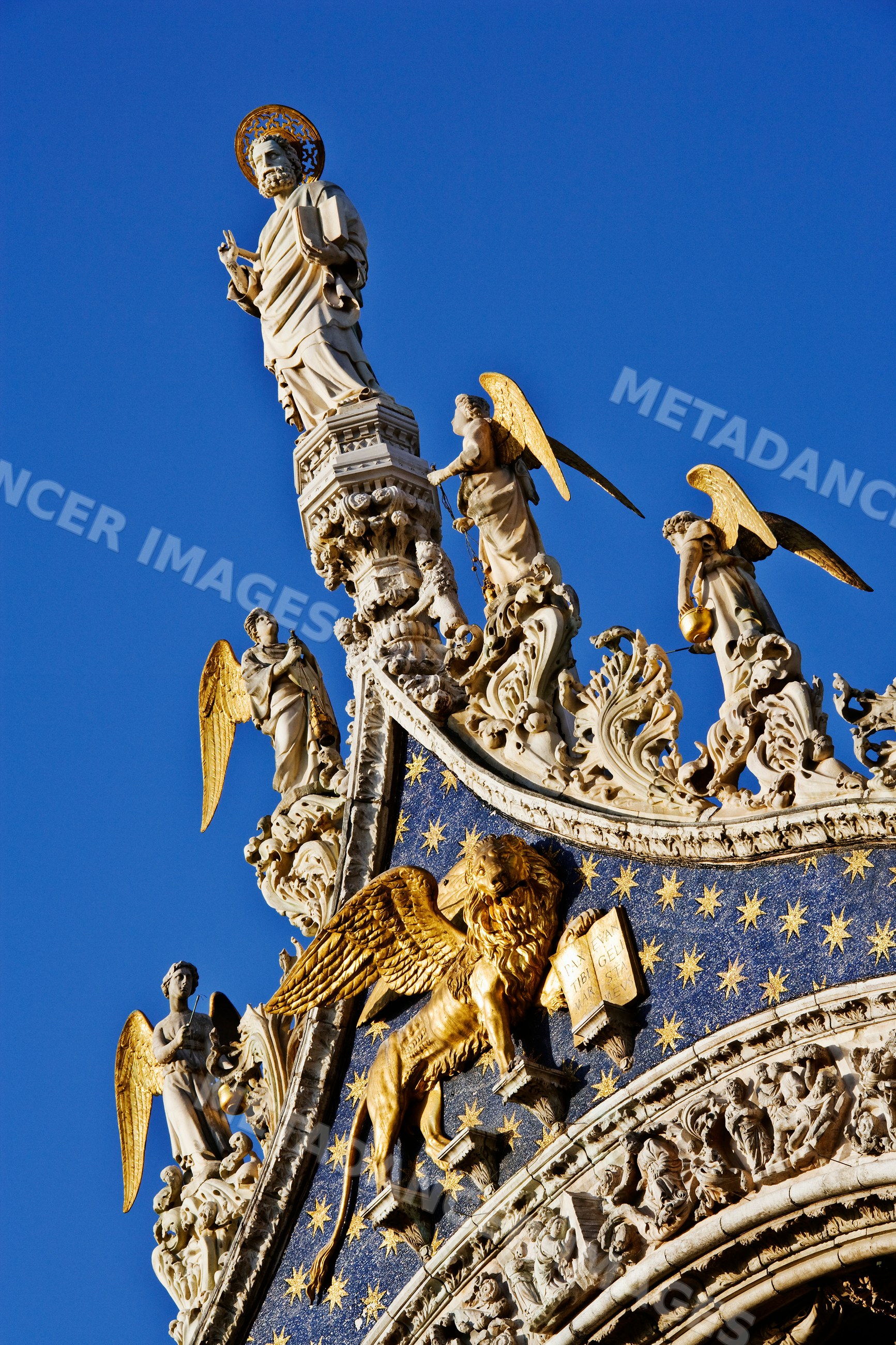Statue of st. mark with angel sculptures and golden lion, italy