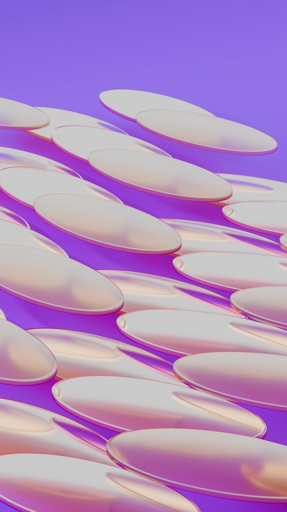 Close-up of translucent softgel capsules stacked on purple background