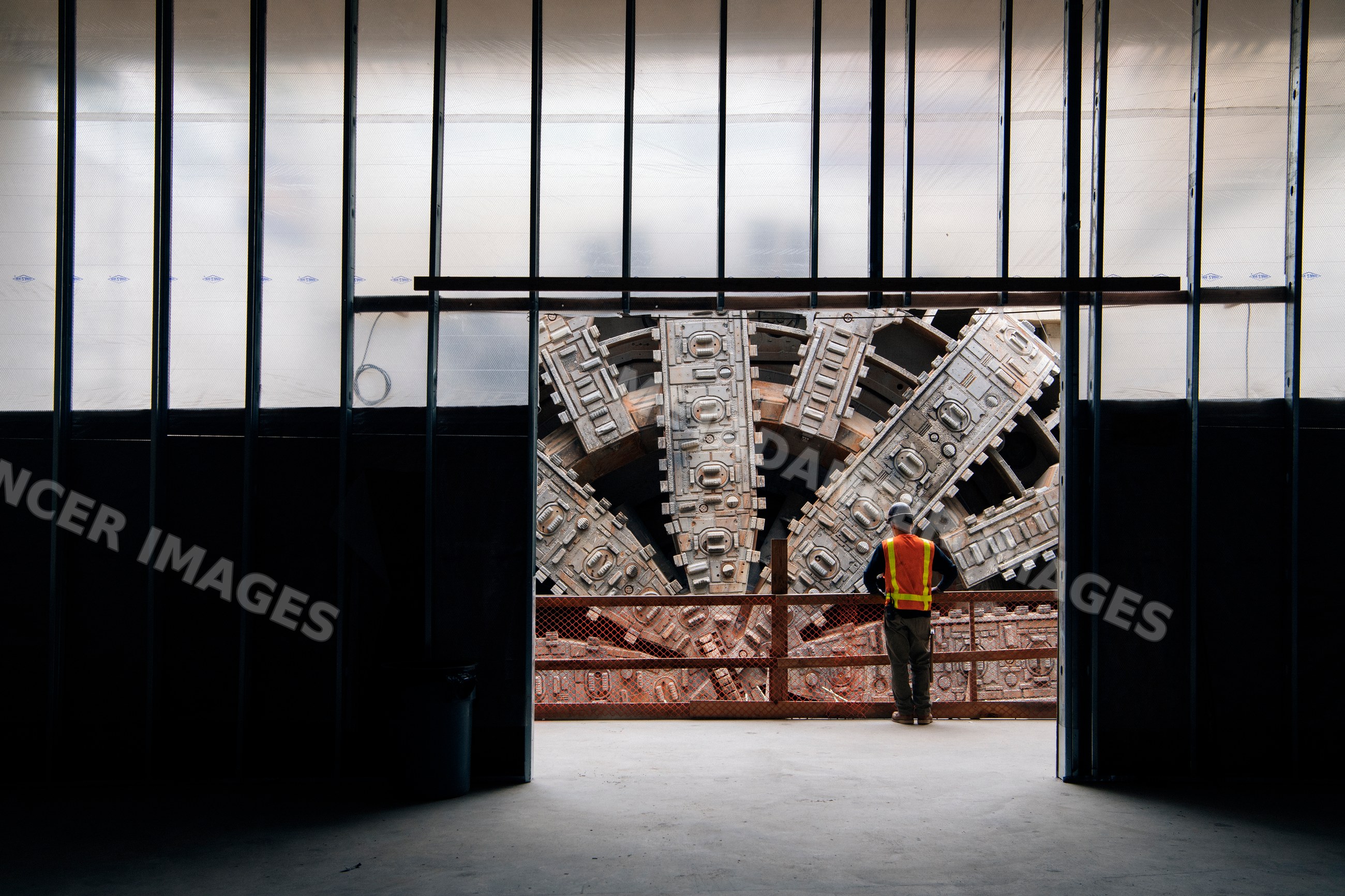 A construction white worker inspects a tunnel boring machine