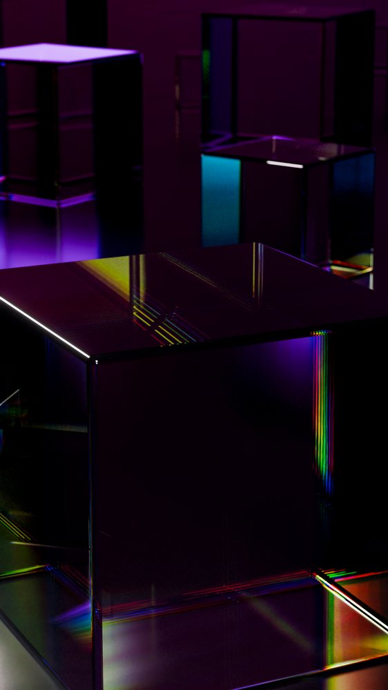 Glass cubes with colorful light reflections on dark surface