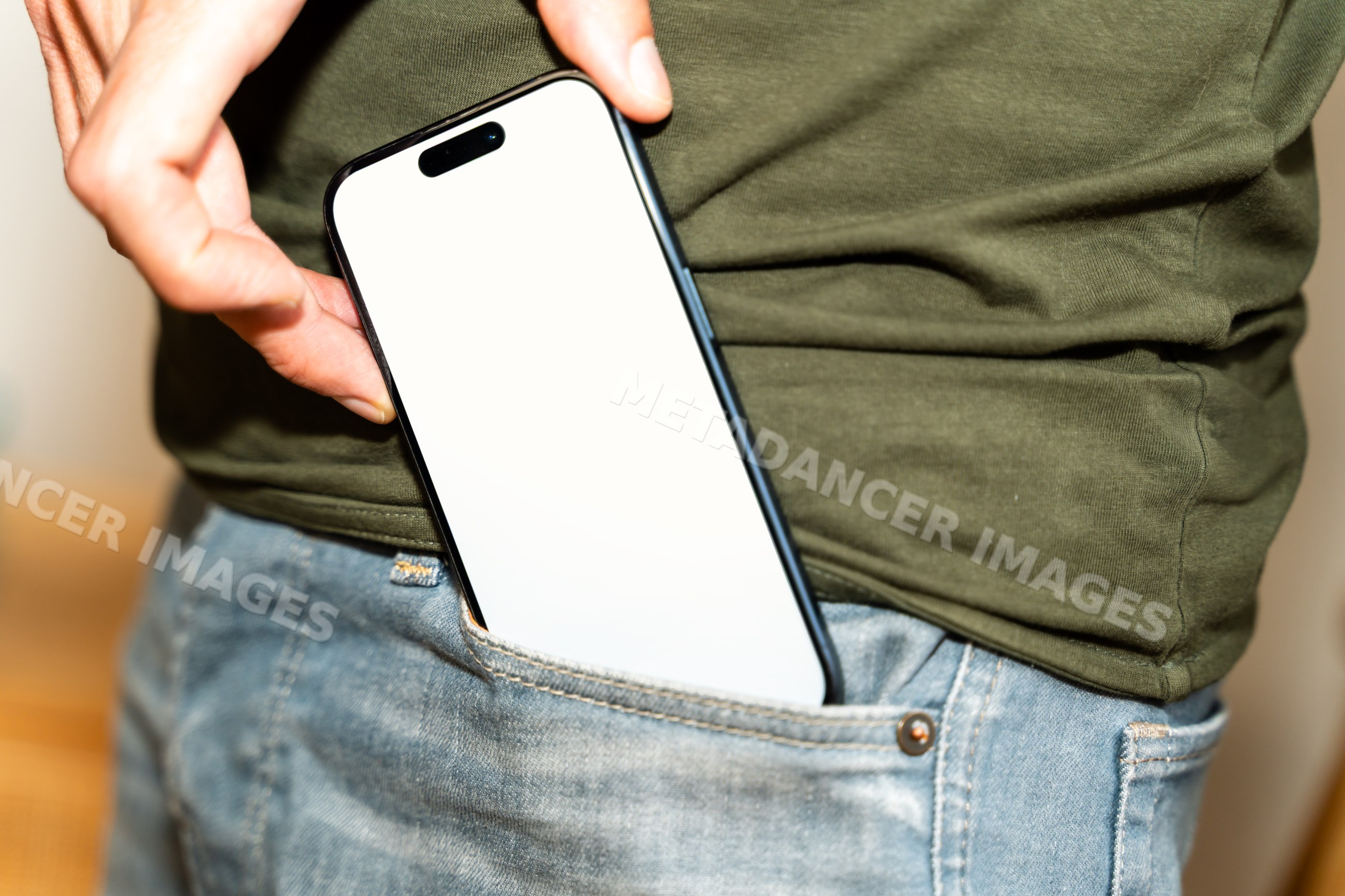 Smartphone being placed into jeans pocket with hand