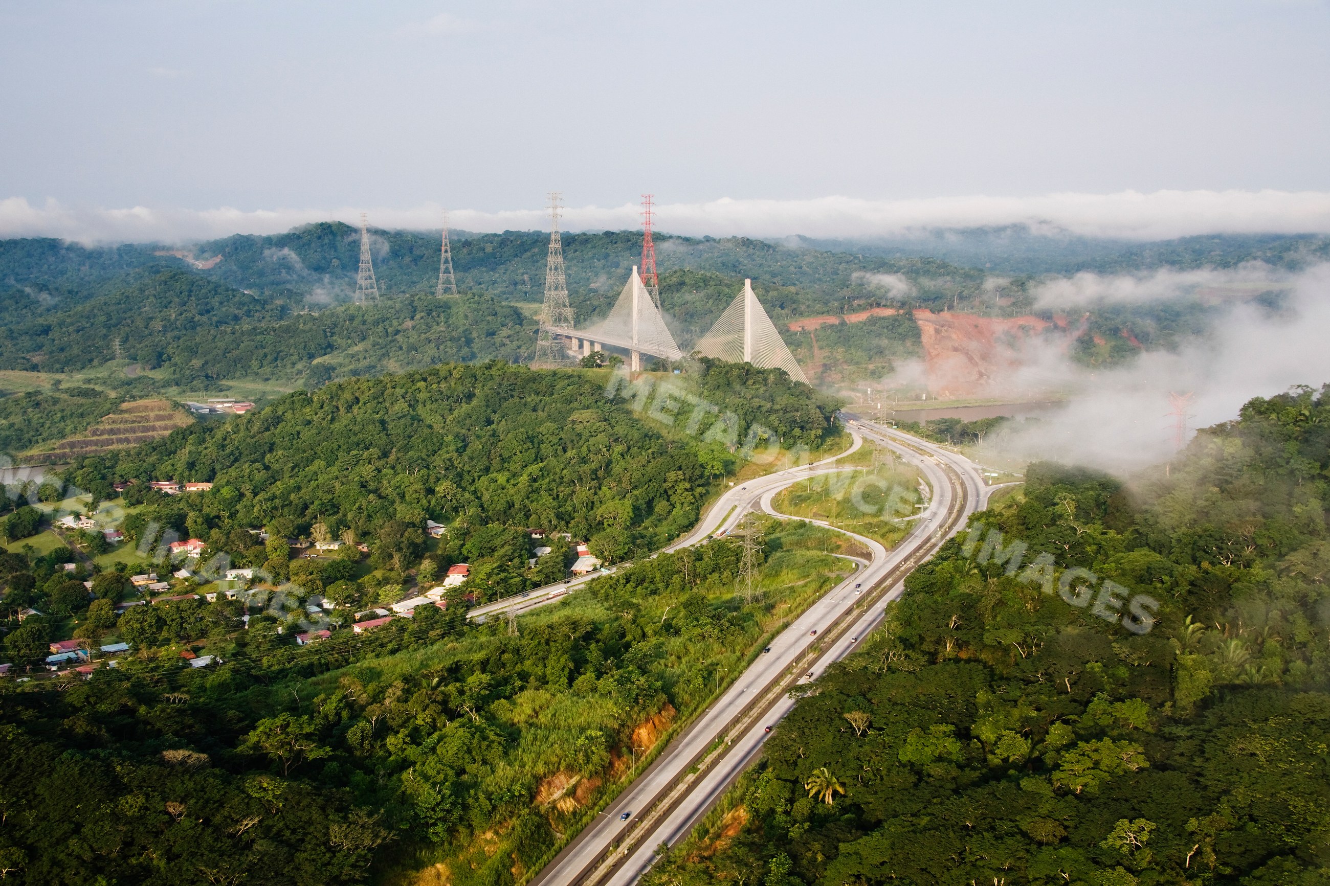 Panama canal bridge spanning tropical forest highway and mist