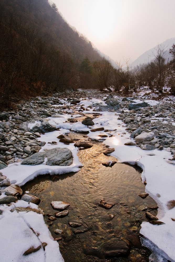 Icy stream flowing through qinling mountains, china