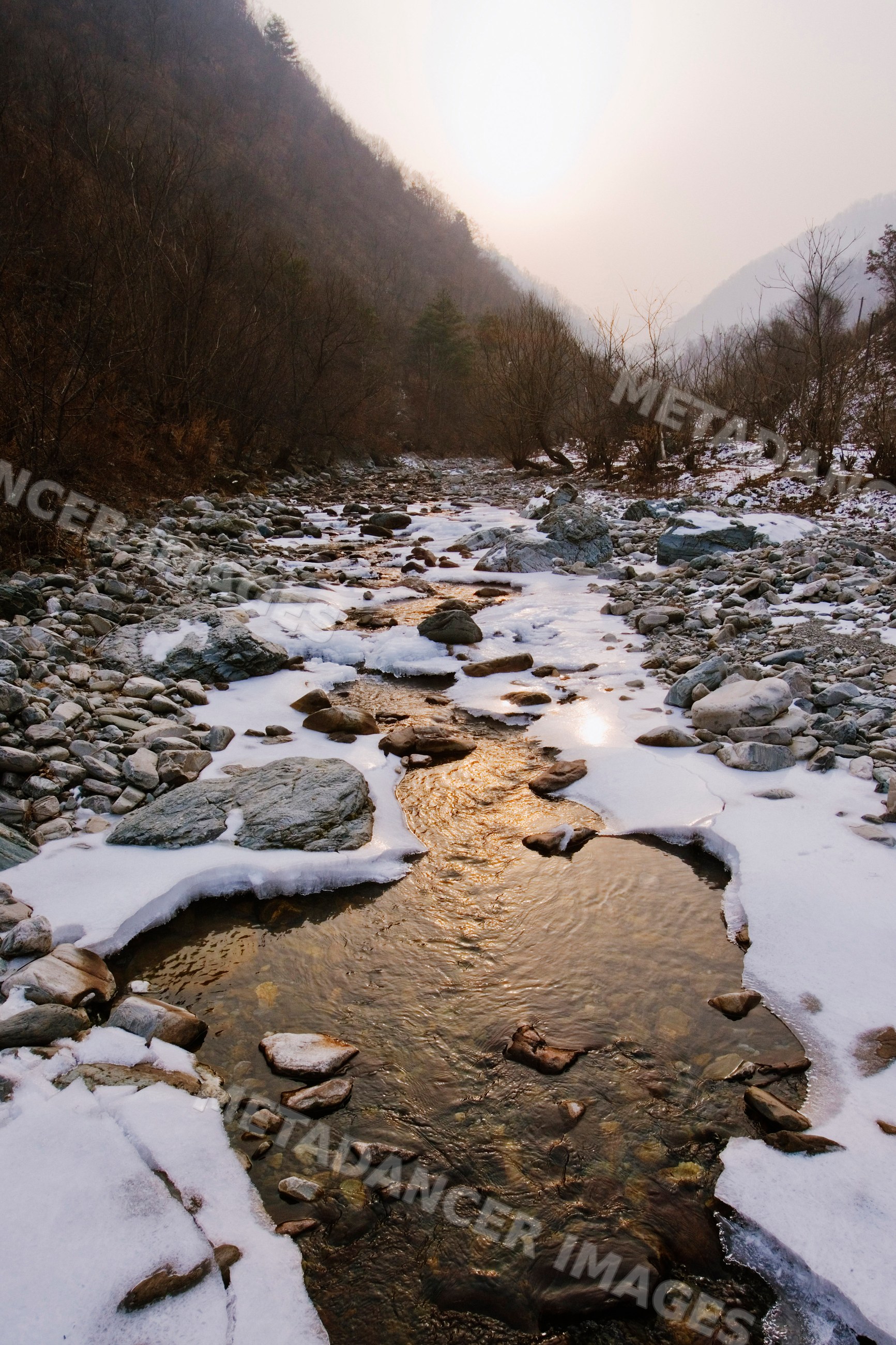 Icy stream flowing through qinling mountains, china
