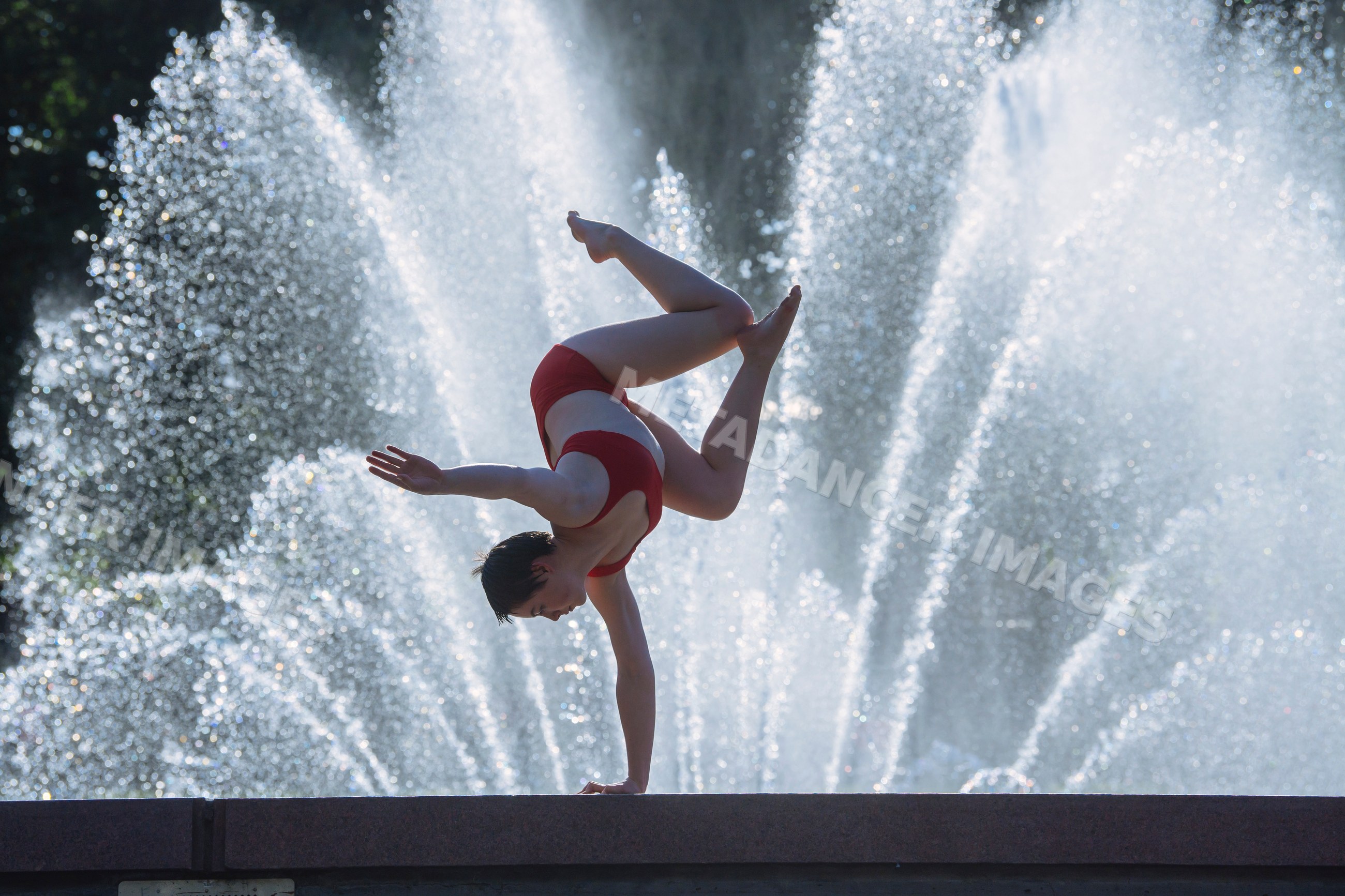 White woman performing one-arm handstand