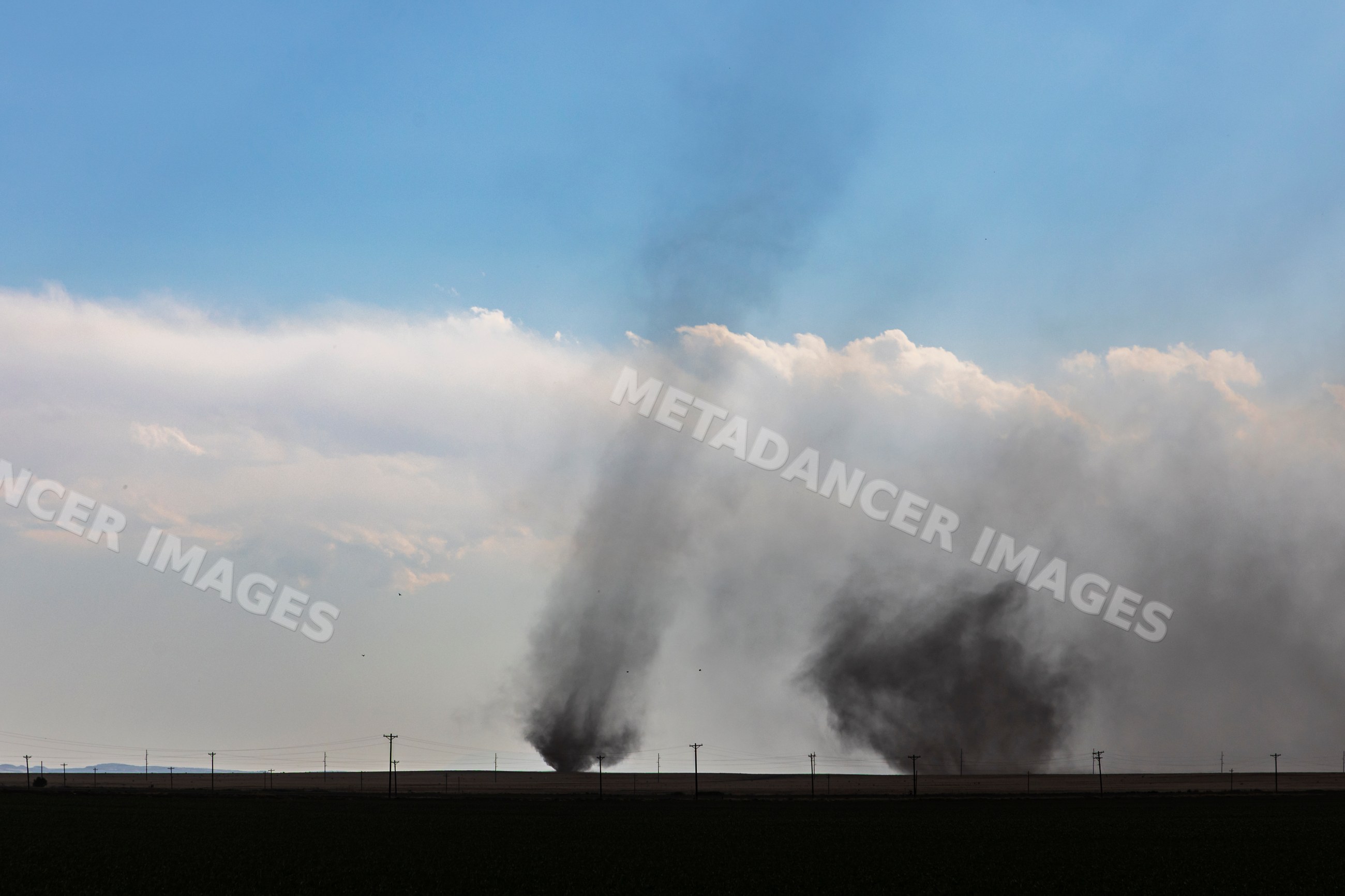 Twin tornadoes lifting dust at county road 2 in fowler colorado
