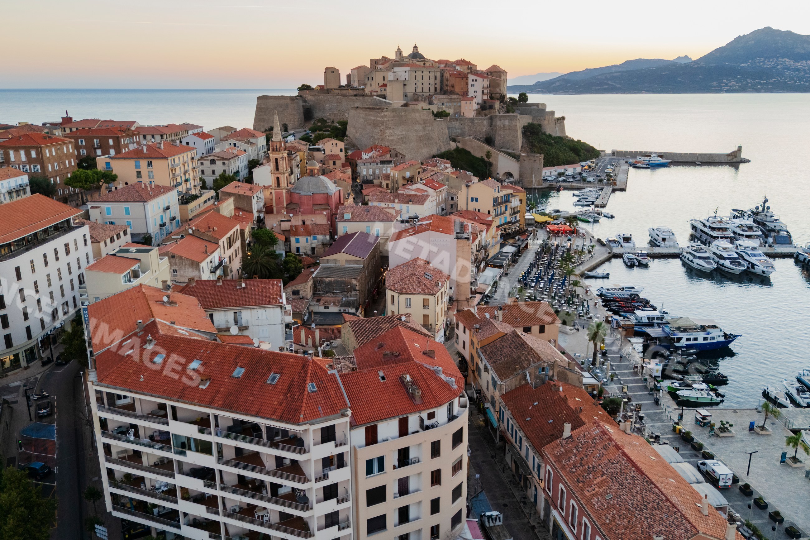 Citadel overlooking Calvi harbor at sunset in corsica, france