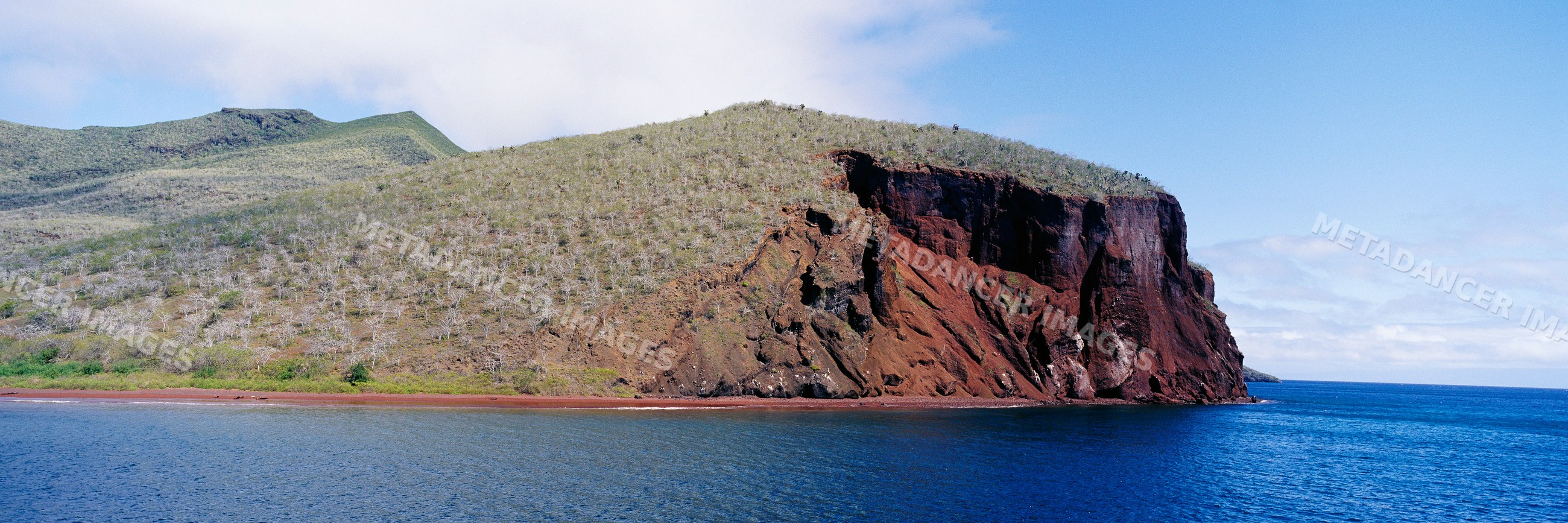 Red rocky cliffs and red beach on isla rabida galapagos islands