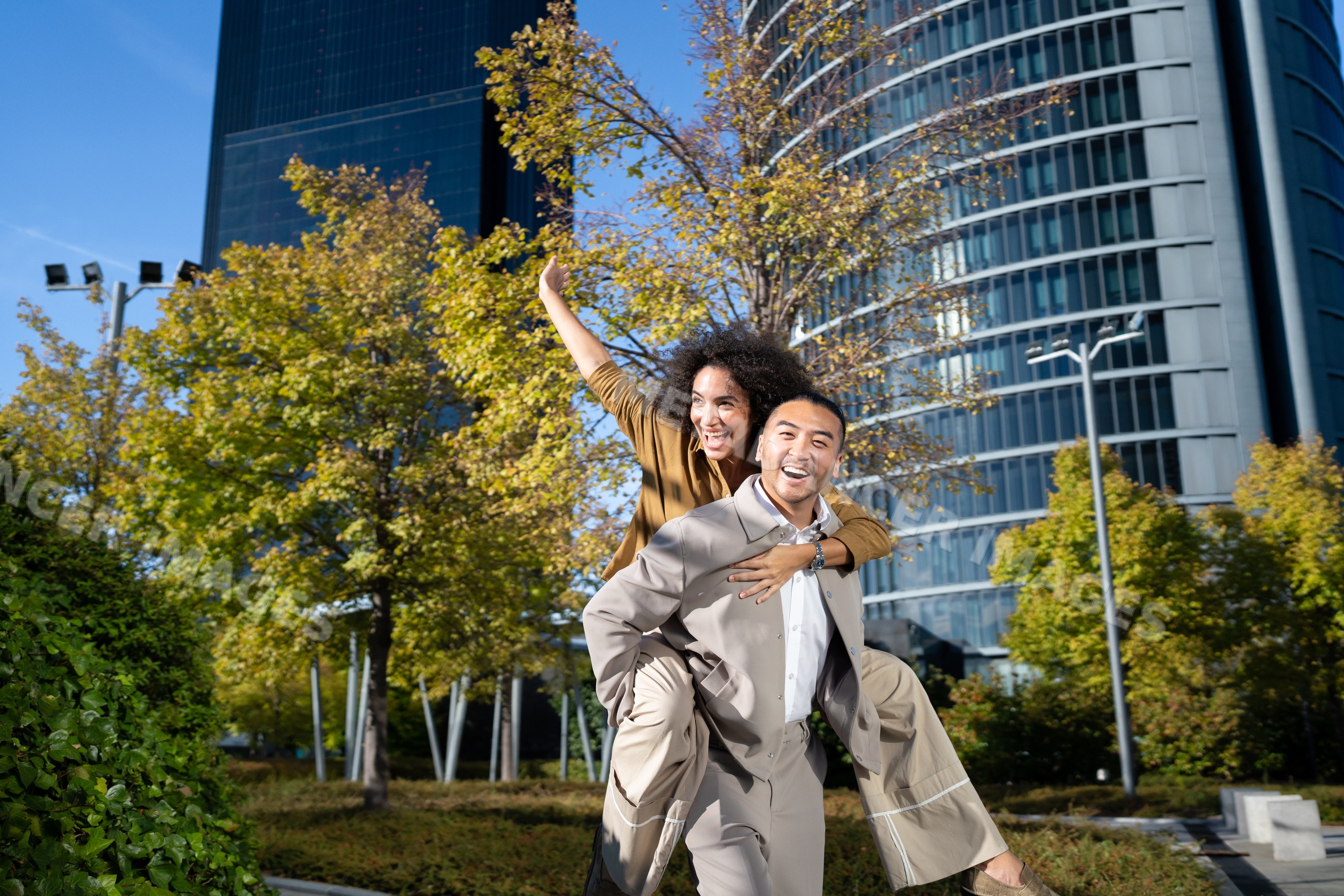 Man giving woman piggyback ride in autumn urban park