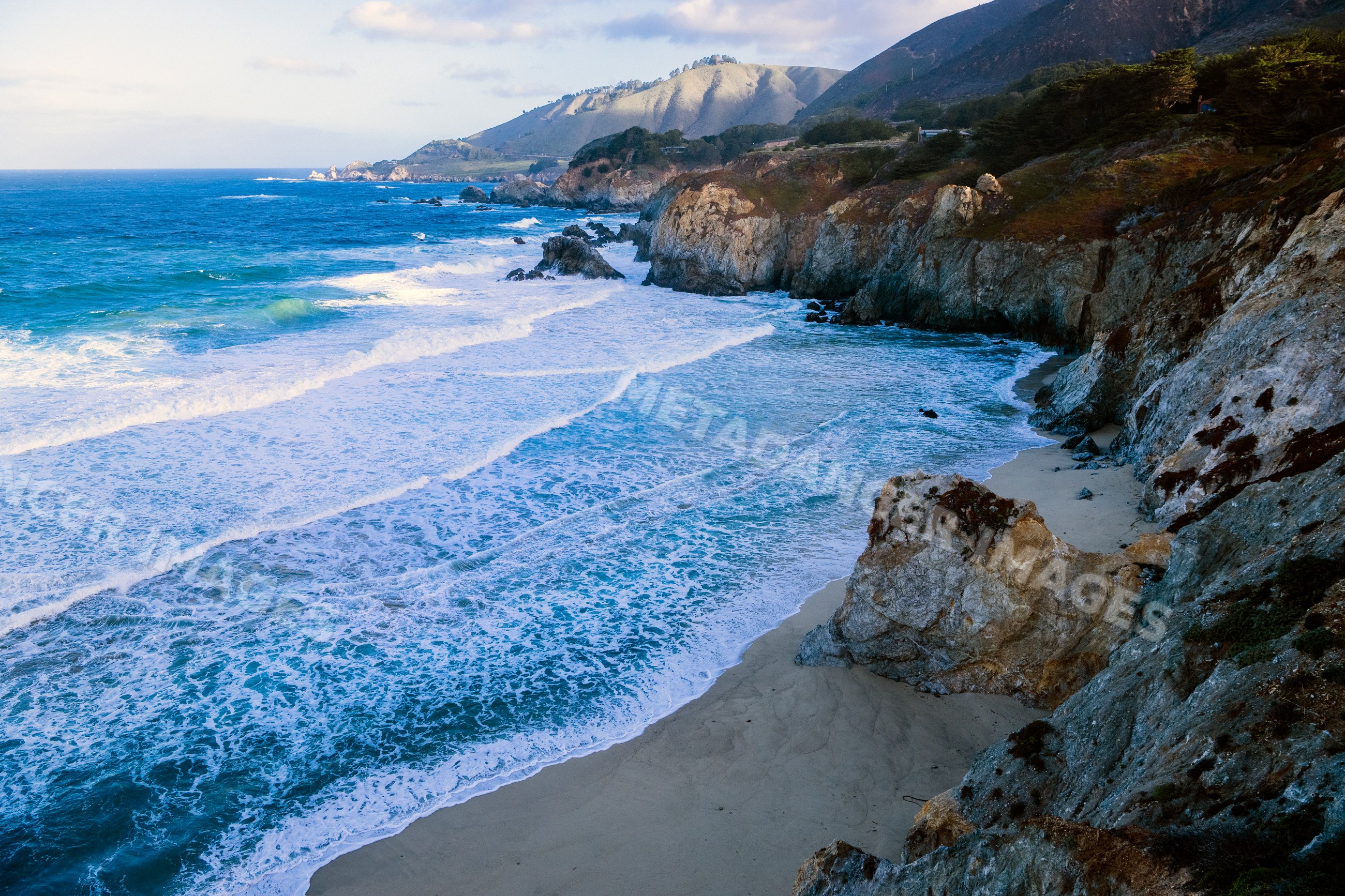 Waves crashing along rocky coastline and beach in a beach